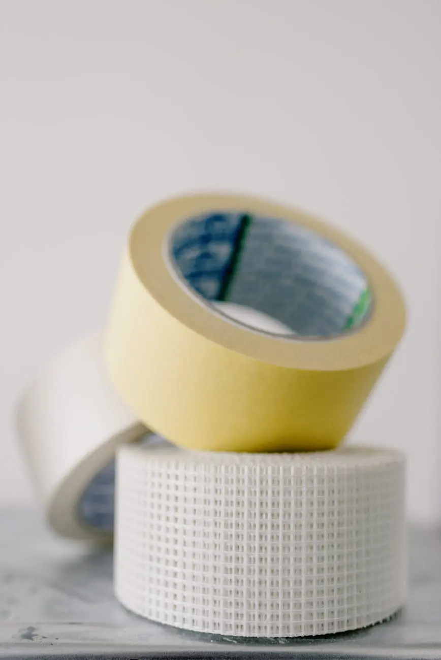 Persona aplicando correctamente cinta masking tape en pared blanca - SOCO Cintas Adhesivas.