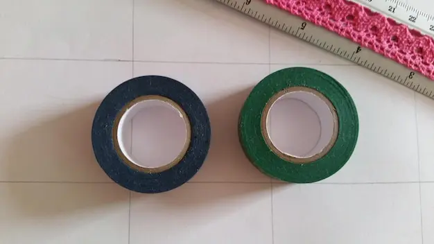 Cinta masking tape sobre superficie de madera, mostrando su uso en pintura - SOCO Cintas Adhesivas.