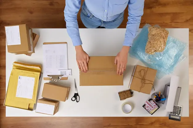 Persona empacando productos con cinta adhesiva y materiales de protección para envío - SOCO Cintas Adhesivas